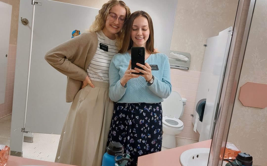 sister missionaries taking mirror selfie with phone